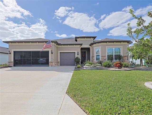 prairie-style home featuring a garage and a front lawn