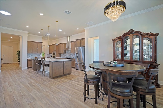 interior space featuring a chandelier, light wood-type flooring, and crown molding