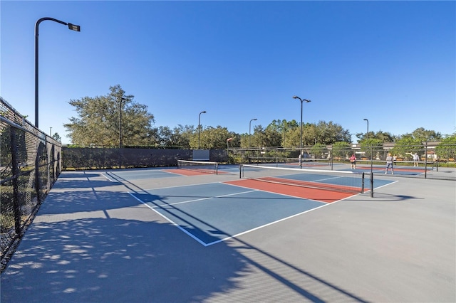 view of tennis court featuring basketball hoop