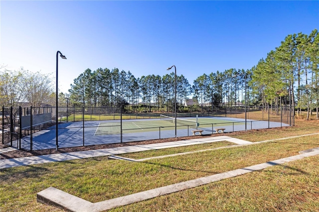 view of tennis court featuring a yard