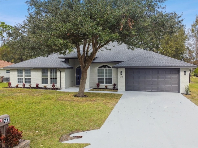 view of front facade with a front yard, central AC, and a garage