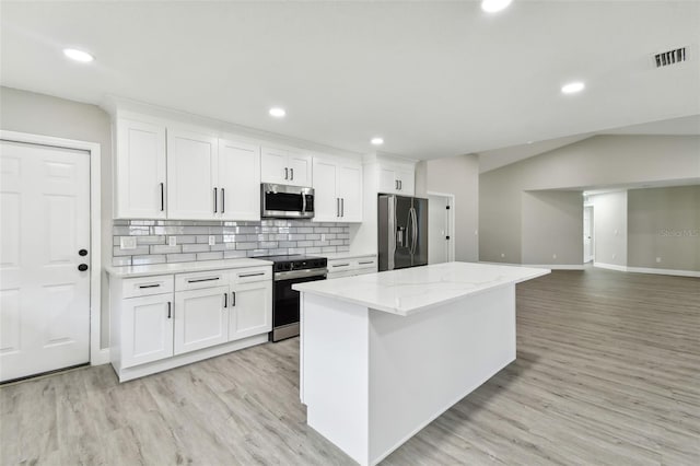 kitchen with white cabinets, appliances with stainless steel finishes, a center island, and light wood-type flooring