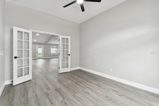 unfurnished room featuring ceiling fan, light wood-type flooring, lofted ceiling, and french doors