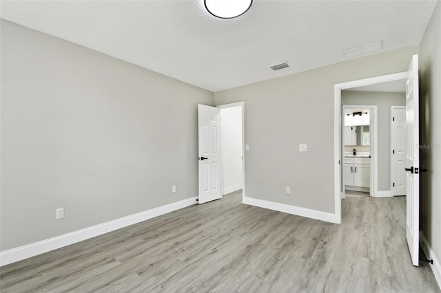 unfurnished bedroom with light hardwood / wood-style floors and a textured ceiling