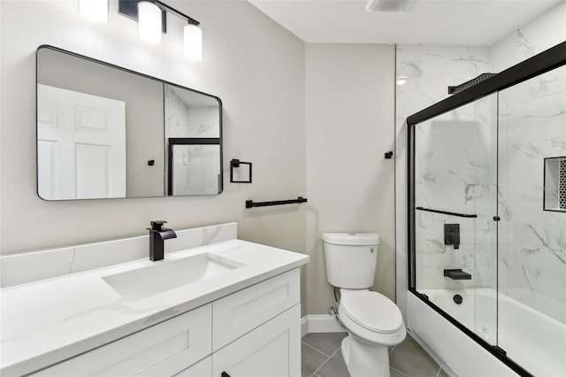 full bathroom featuring toilet, vanity, tile patterned floors, and enclosed tub / shower combo