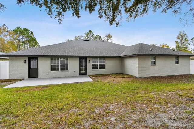 rear view of property featuring a yard and a patio area