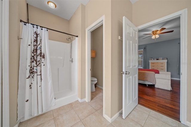 bathroom featuring hardwood / wood-style flooring, toilet, walk in shower, and ceiling fan