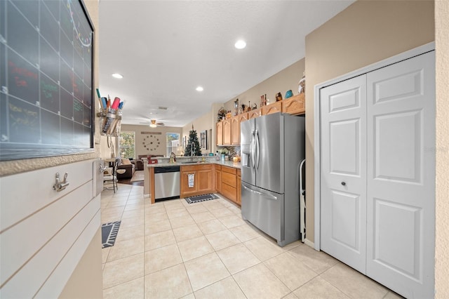 kitchen featuring kitchen peninsula, light tile patterned floors, stainless steel appliances, and ceiling fan