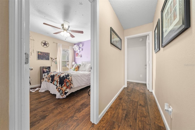 bedroom featuring ceiling fan, dark hardwood / wood-style flooring, and a textured ceiling