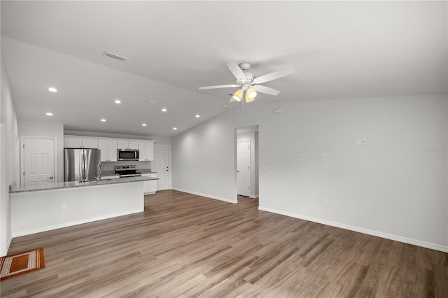 interior space featuring ceiling fan, lofted ceiling, and light wood-type flooring