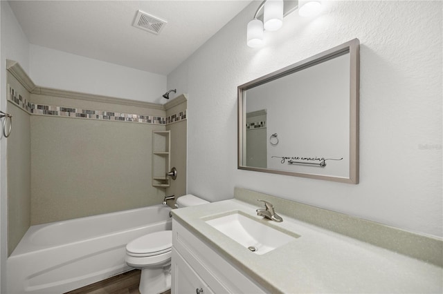 full bathroom featuring shower / bathing tub combination, vanity, hardwood / wood-style flooring, toilet, and a textured ceiling