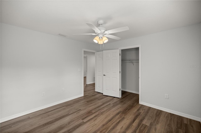 unfurnished bedroom featuring a closet, dark hardwood / wood-style floors, and ceiling fan