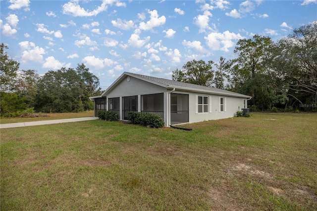 30 Maple Crse, Ocklawaha, FL 32179 - view of side of home with a sunroom, stucco siding, a lawn, and driveway