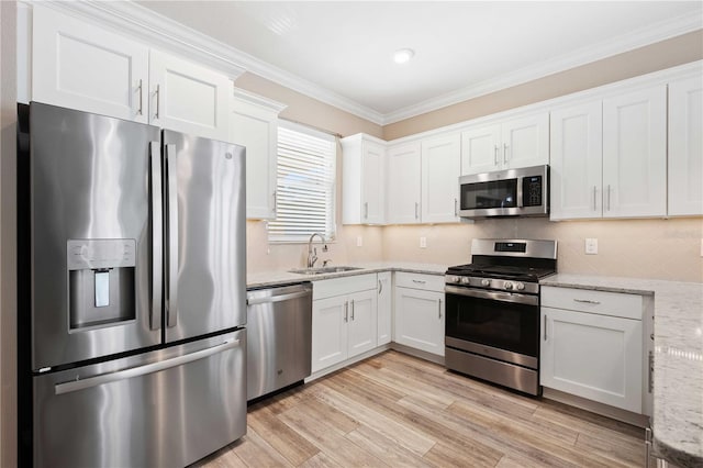 kitchen featuring light stone countertops, white cabinetry, sink, and appliances with stainless steel finishes