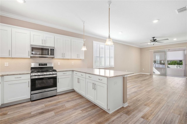 kitchen with hanging light fixtures, light hardwood / wood-style flooring, ceiling fan, appliances with stainless steel finishes, and white cabinetry