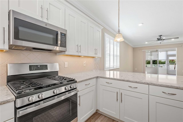 kitchen with ceiling fan, ornamental molding, appliances with stainless steel finishes, tasteful backsplash, and white cabinetry