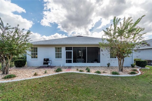 back of property featuring a sunroom and a yard