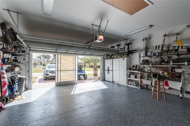 garage with a workshop area and a garage door opener