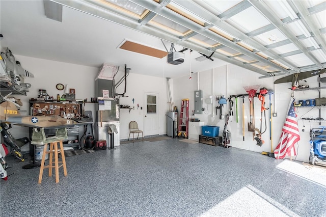 garage featuring a workshop area, electric panel, a garage door opener, and water heater