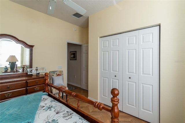 bedroom with light parquet floors, a closet, and ceiling fan