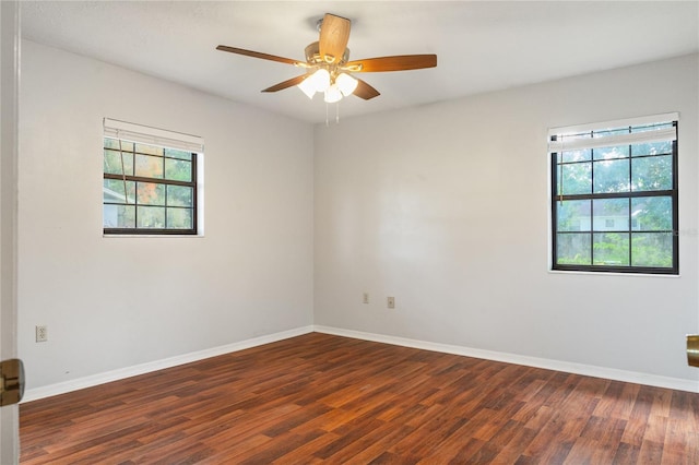 empty room featuring dark hardwood / wood-style floors, ceiling fan, and a wealth of natural light