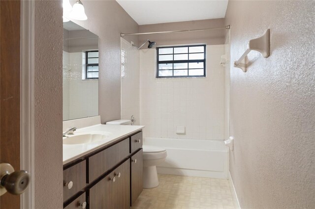 full bathroom with tiled shower / bath, plenty of natural light, vanity, and toilet