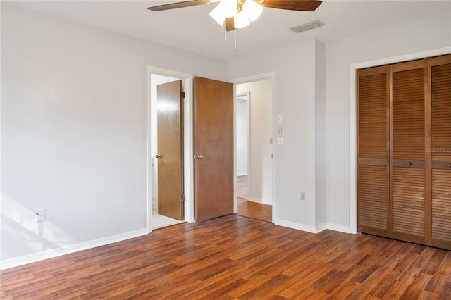 unfurnished bedroom featuring dark hardwood / wood-style flooring, a closet, and ceiling fan