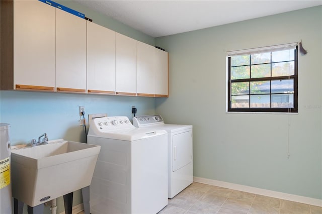 laundry area featuring washing machine and dryer, sink, and cabinets