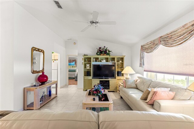 living room with ceiling fan, light tile patterned floors, and vaulted ceiling