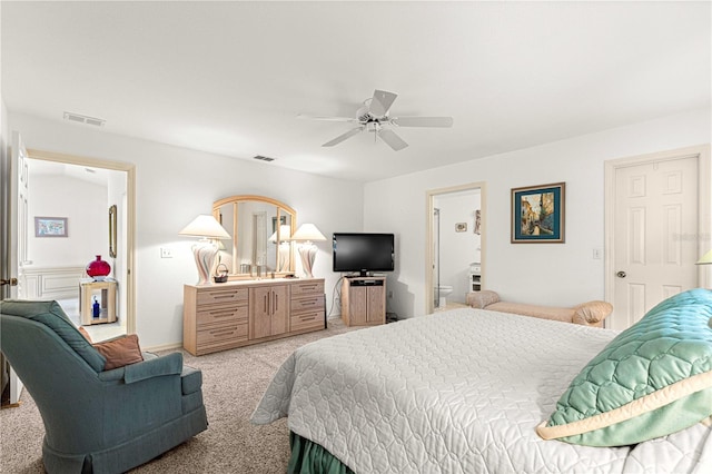 carpeted bedroom with ensuite bathroom and ceiling fan