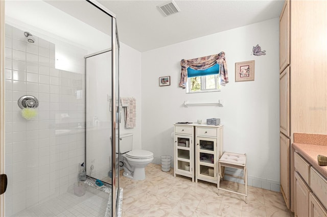 bathroom featuring vanity, toilet, and a shower with door