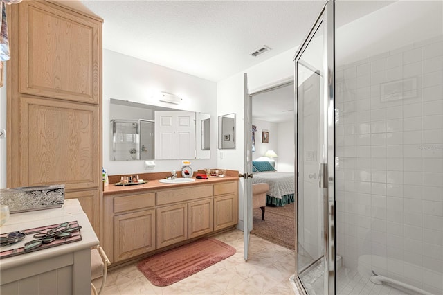 bathroom featuring a textured ceiling, vanity, and an enclosed shower