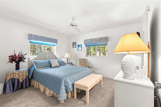 carpeted bedroom with multiple windows and ceiling fan