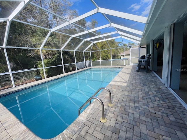 view of swimming pool with a patio and glass enclosure