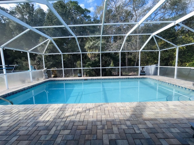 view of pool with glass enclosure and a patio area