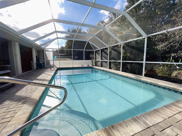 view of swimming pool with a patio and a lanai