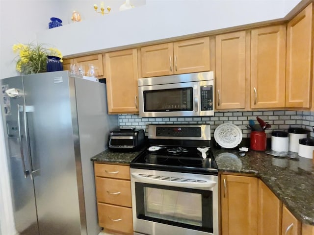 kitchen with dark stone countertops, appliances with stainless steel finishes, and tasteful backsplash