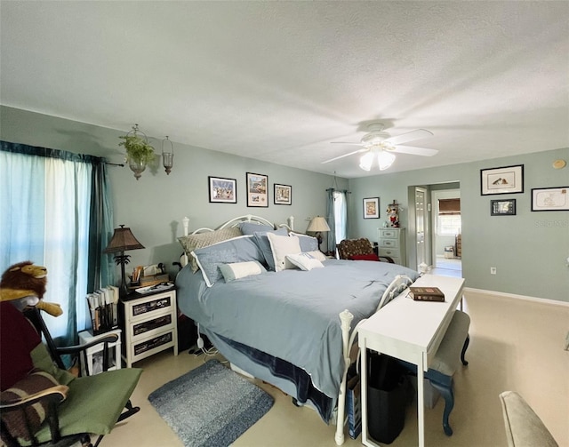 carpeted bedroom with ceiling fan and a textured ceiling