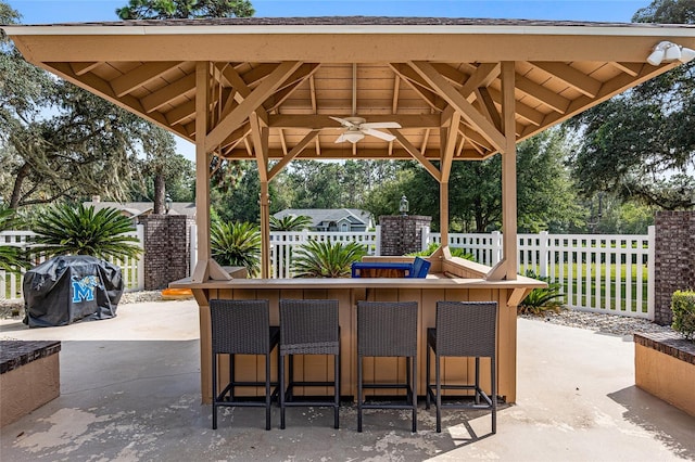 view of patio with a gazebo, ceiling fan, and an outdoor bar