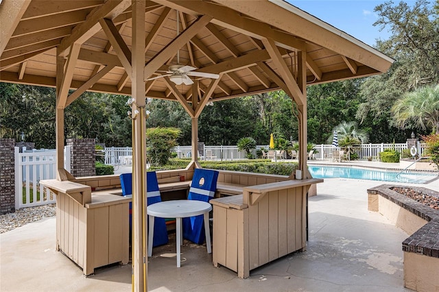 view of patio / terrace featuring a gazebo, ceiling fan, and a fenced in pool