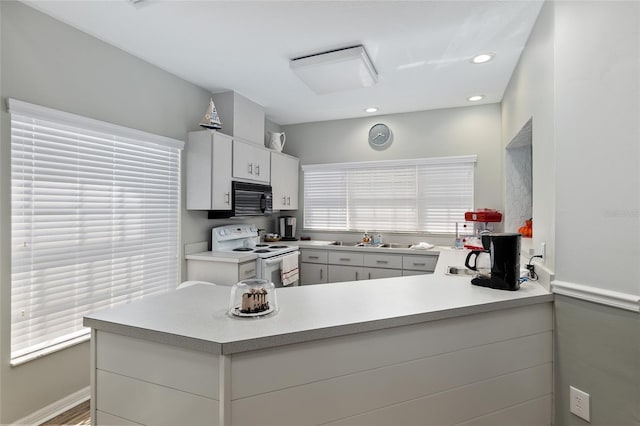 kitchen with kitchen peninsula and white range with electric stovetop