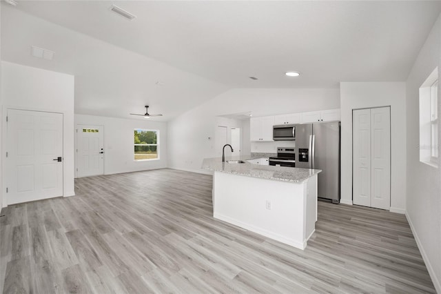 kitchen with appliances with stainless steel finishes, vaulted ceiling, ceiling fan, light hardwood / wood-style flooring, and white cabinets