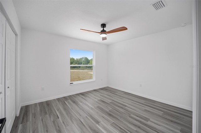 unfurnished bedroom with ceiling fan, light wood-type flooring, and a closet