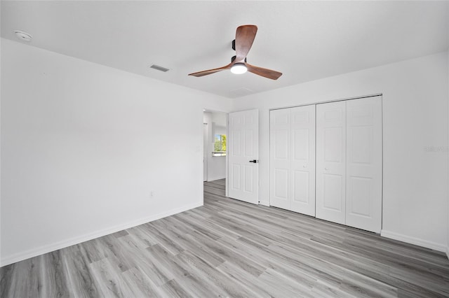 unfurnished bedroom with ceiling fan, a closet, and light hardwood / wood-style floors