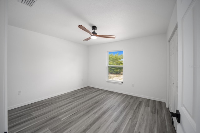 unfurnished bedroom featuring hardwood / wood-style flooring, ceiling fan, a textured ceiling, and a closet