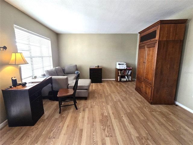 living area with light wood-type flooring and a textured ceiling