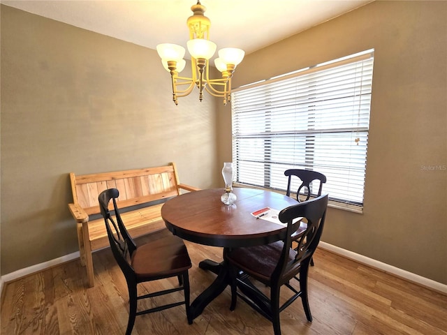 dining area featuring wood-type flooring and a notable chandelier