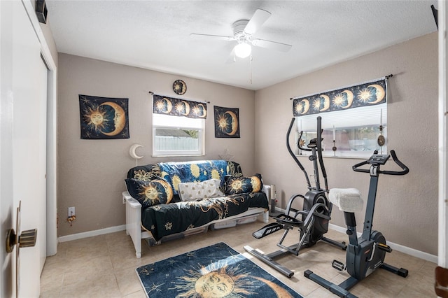 exercise room featuring ceiling fan and light tile patterned floors