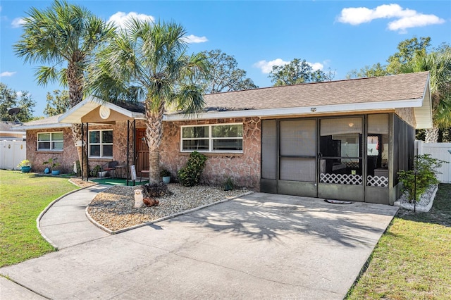 ranch-style house with a sunroom and a front yard