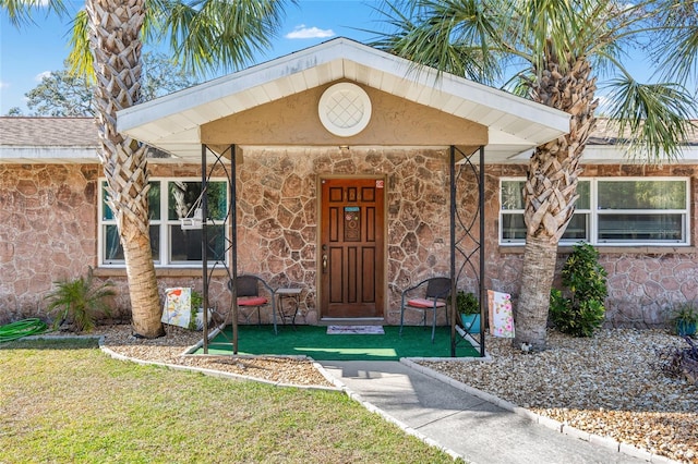 property entrance featuring a lawn